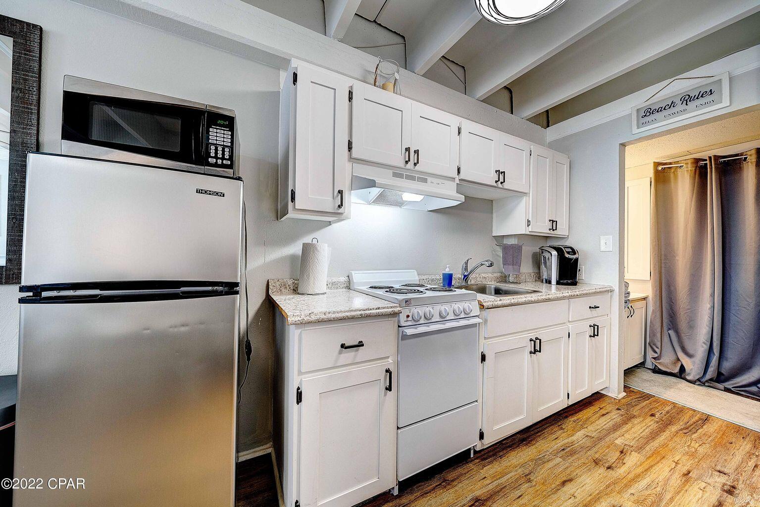 14401 Front Beach Road, Unit 434 Panama City Beach, FL 32413 - Photo 10 of 36 a kitchen with stainless steel appliances a refrigerator sink and microwave