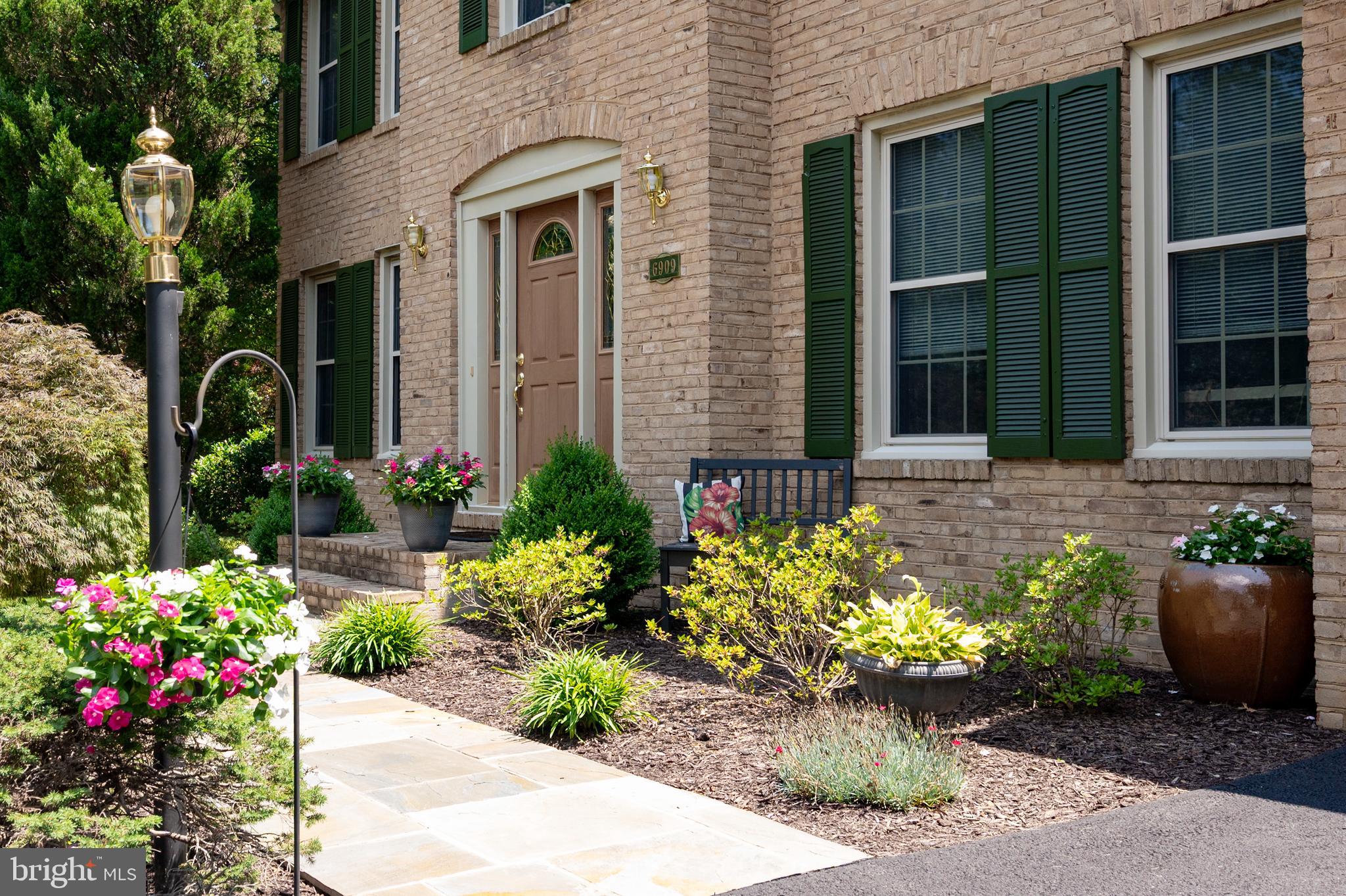 6909 Trillium Lane Springfield, VA 22152 - Photo 4 of 36 a front view of a house with a garden