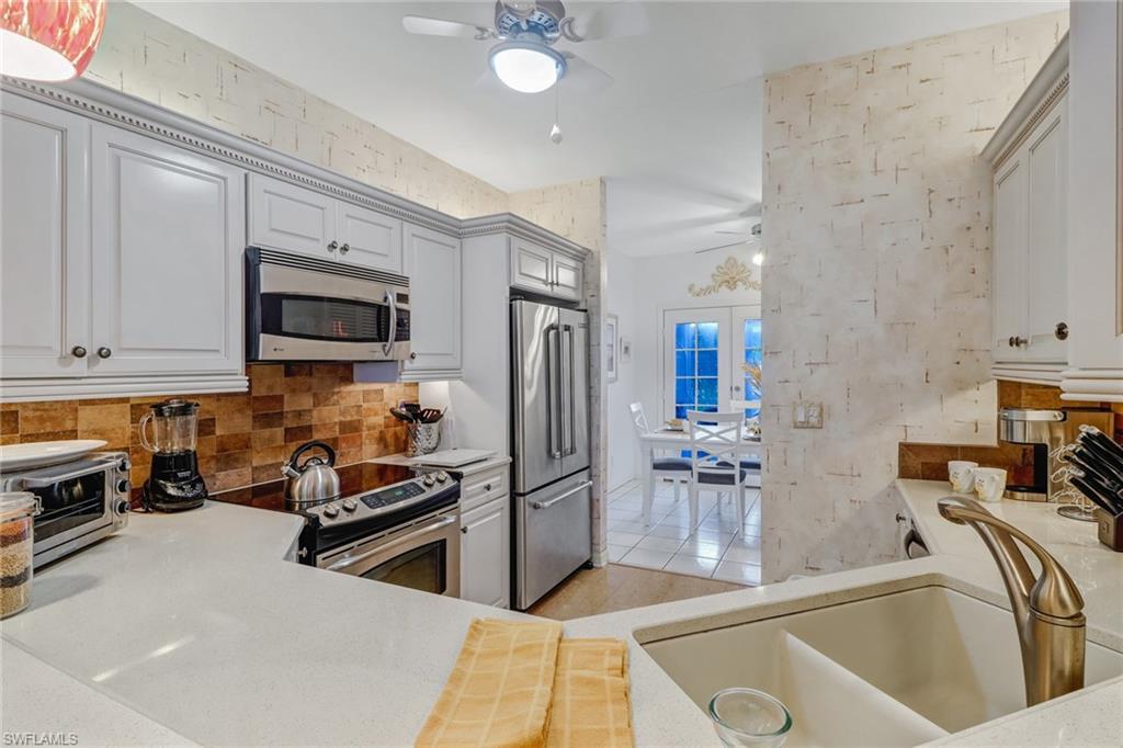 7108 Barrington Circle, Unit 101 Naples, FL 34108 - Photo 12 of 30 a kitchen with stainless steel appliances granite countertop a sink and a refrigerator