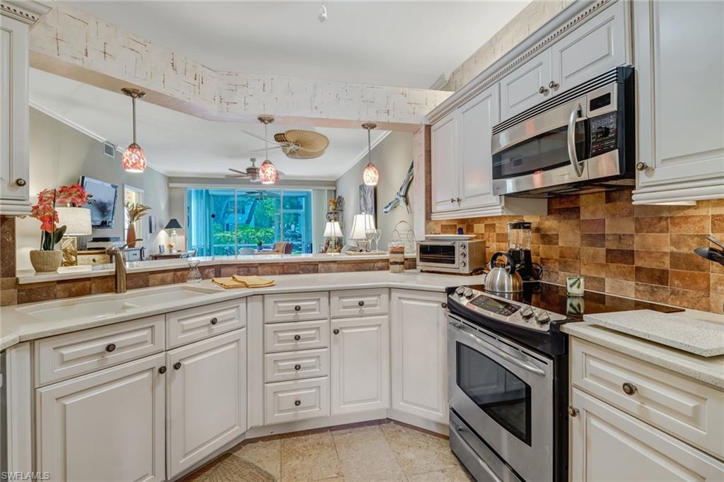 7108 Barrington Circle, Unit 101 Naples, FL 34108 - Photo 14 of 30 a kitchen with stainless steel appliances granite countertop a sink a stove and cabinets
