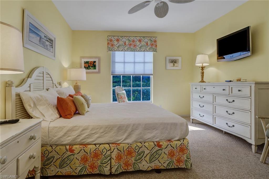 7108 Barrington Circle, Unit 101 Naples, FL 34108 - Photo 16 of 30 a bedroom with a bed and flat screen tv