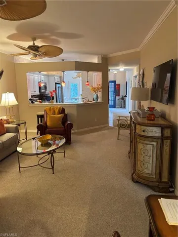 a living room with furniture and a ceiling fan