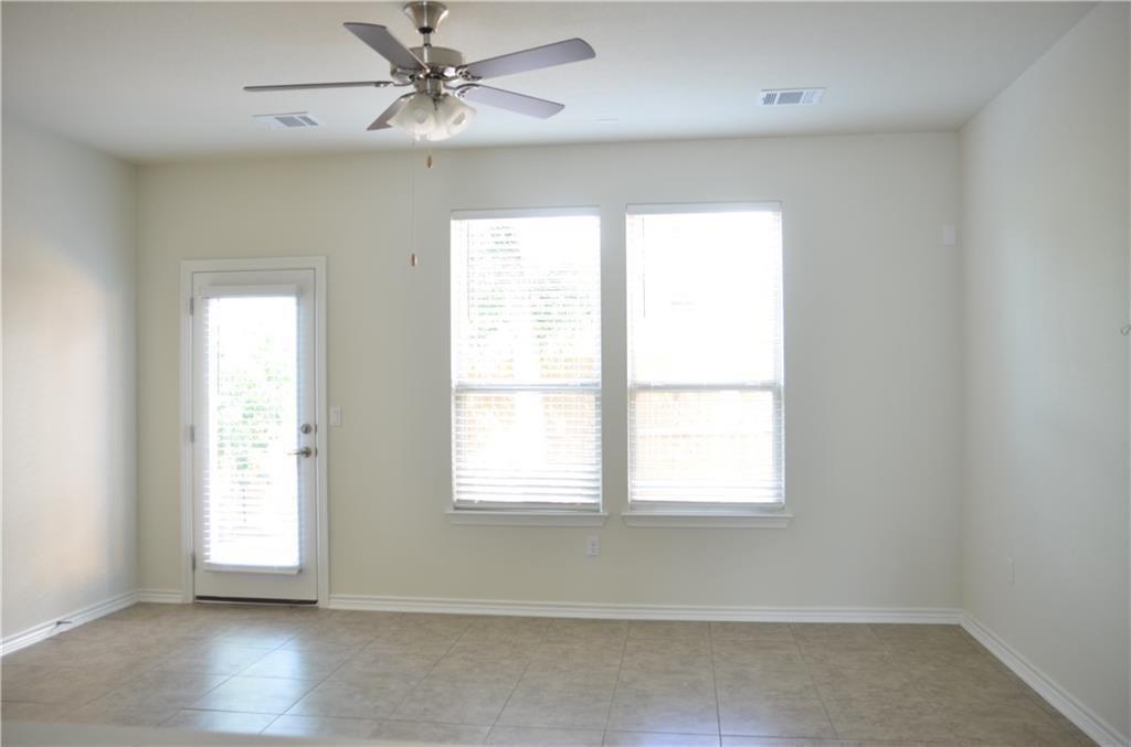 14403 McCoy Loop Austin, TX 78717 - Photo 10 of 29 A living space offers tiled flooring and ample natural light through multiple windows and a glass-paneled door.