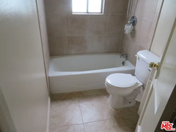 a white toilet sitting next to a bath tub