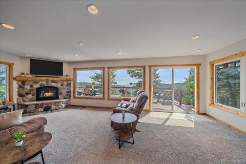 a living room with furniture a fireplace and a large window