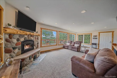 a living room with furniture large window and a fireplace
