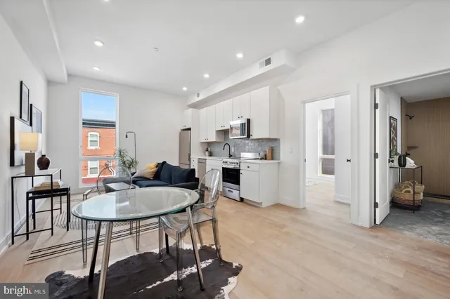 a living room with furniture a dining table and kitchen view
