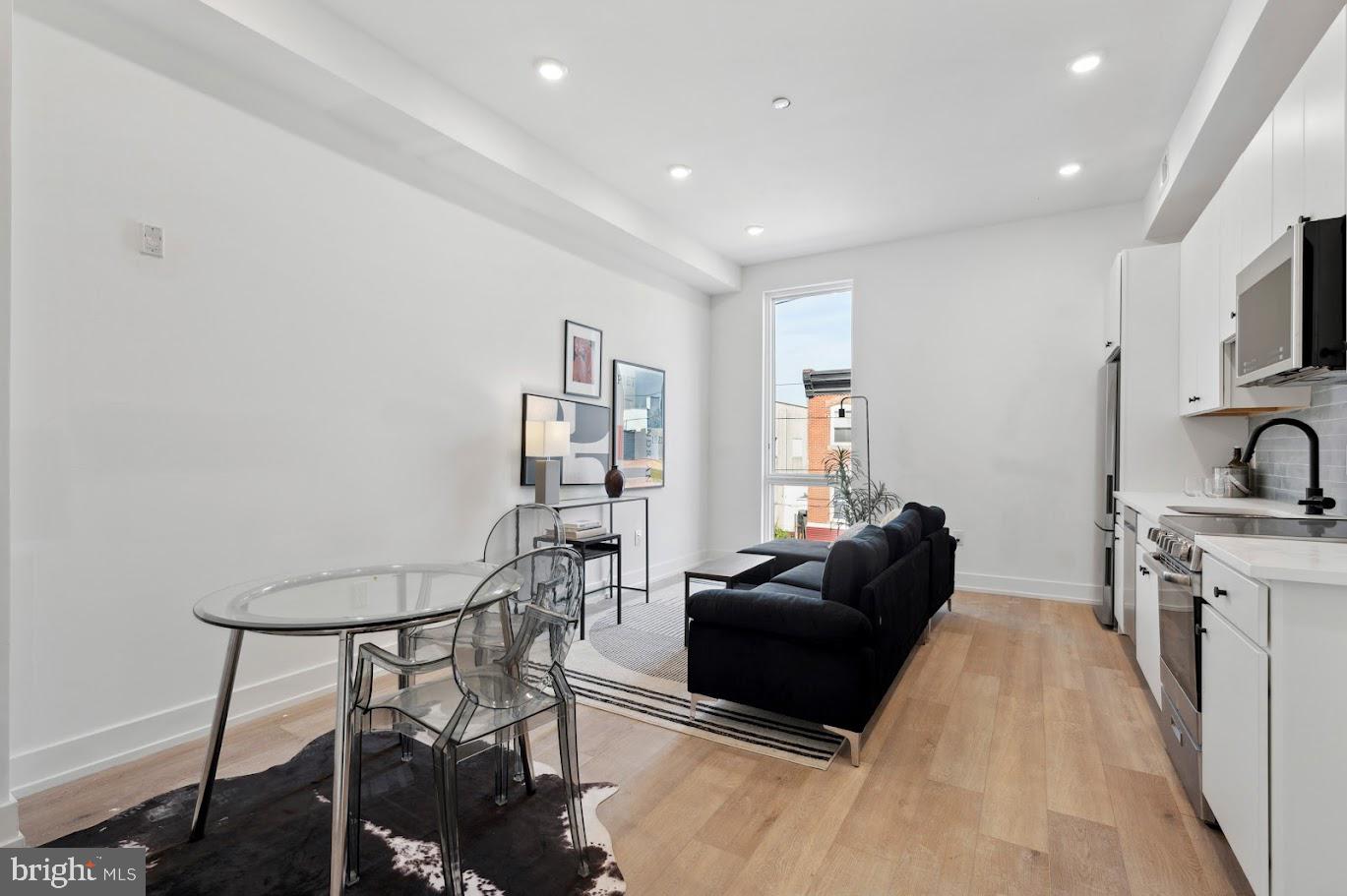 3037 Richmond Street, Unit 107 Philadelphia, PA 19134 - Photo 2 of 15 a living room with furniture a fireplace and a flat screen tv