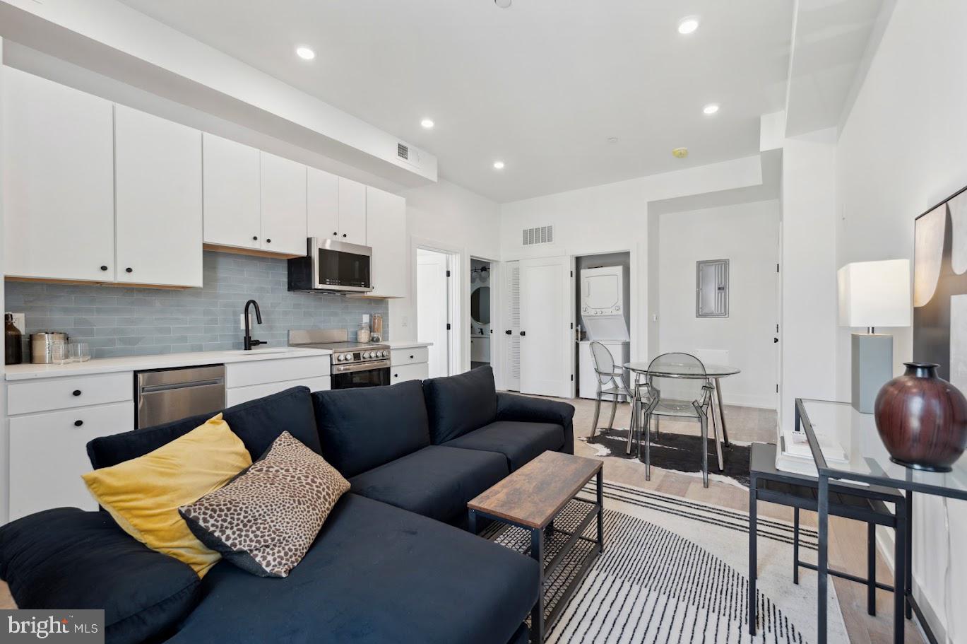 3037 Richmond Street, Unit 107 Philadelphia, PA 19134 - Photo 4 of 15 a living room with furniture and a view of kitchen