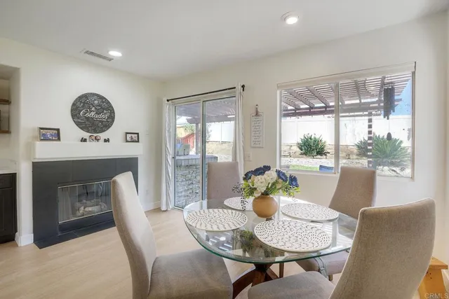 a dining room with furniture a fireplace and large window