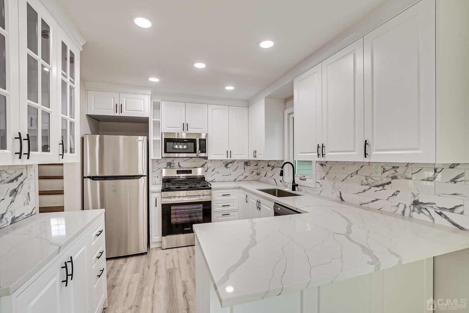 8 Amman Road Edison, NJ 08817 - Photo 21 of 39 a kitchen with stainless steel appliances granite countertop a refrigerator sink and cabinets