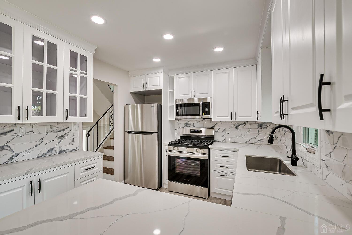 8 Amman Road Edison, NJ 08817 - Photo 22 of 39 a kitchen with white cabinets and stainless steel appliances