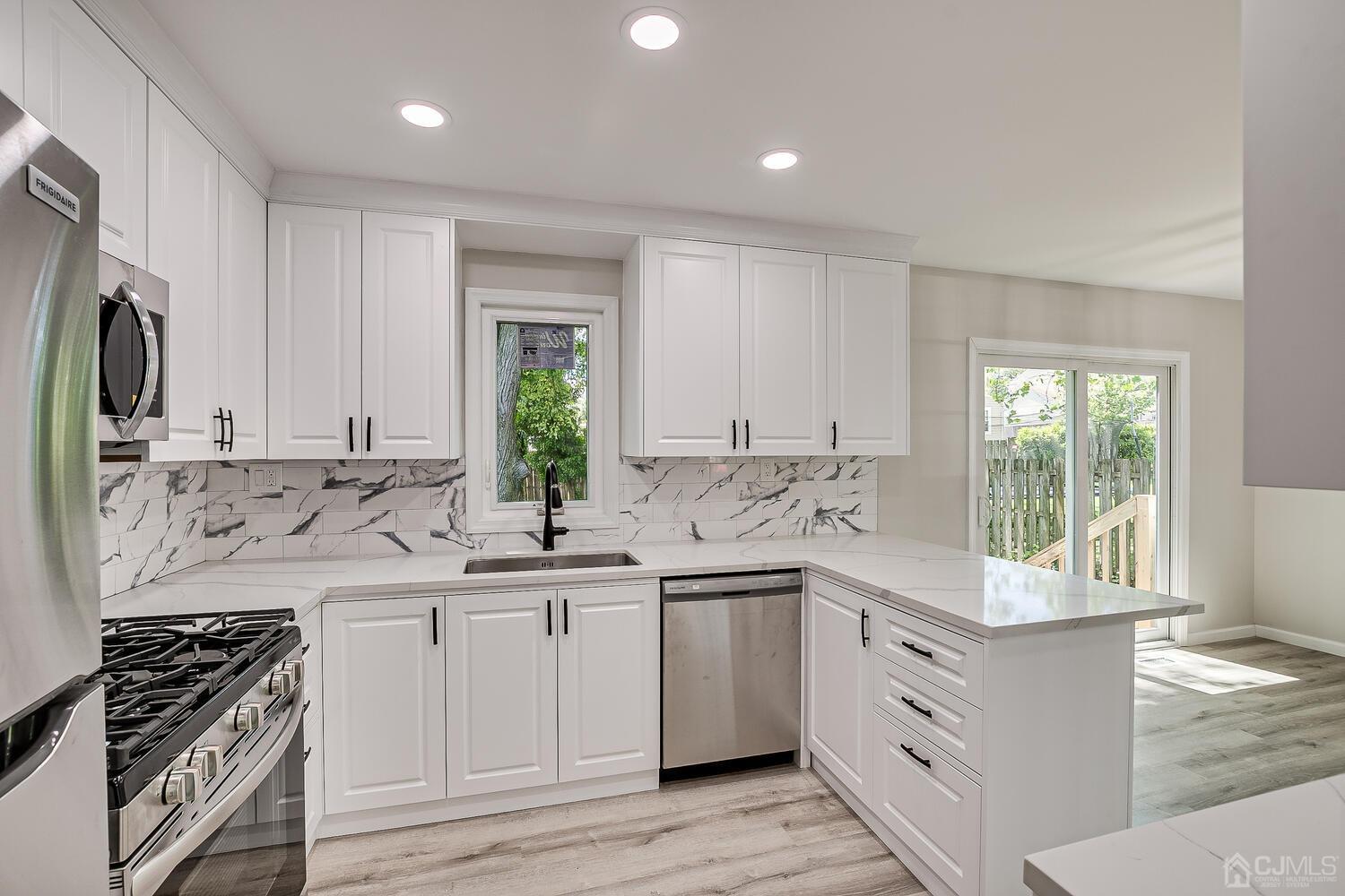 8 Amman Road Edison, NJ 08817 - Photo 23 of 39 a kitchen with a sink stove and cabinets