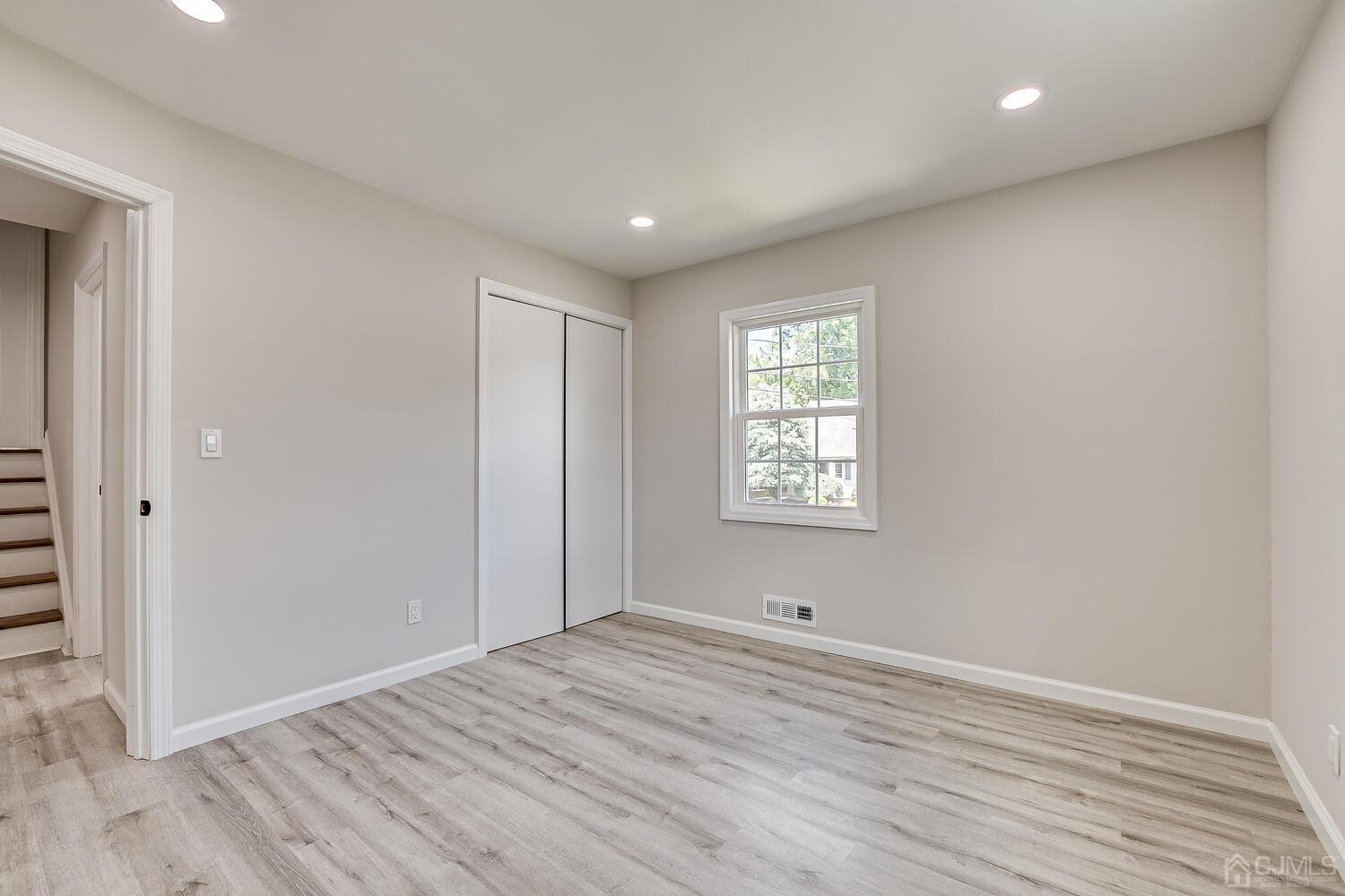 8 Amman Road Edison, NJ 08817 - Photo 33 of 39 wooden floor in an empty room with a window