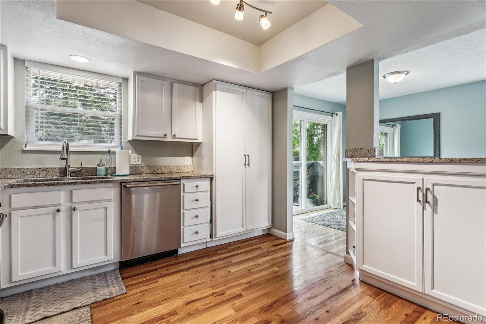 4844 Scranton Court Denver, CO 80239 - Photo 2 of 25 a kitchen with granite countertop a sink cabinets and wooden floor