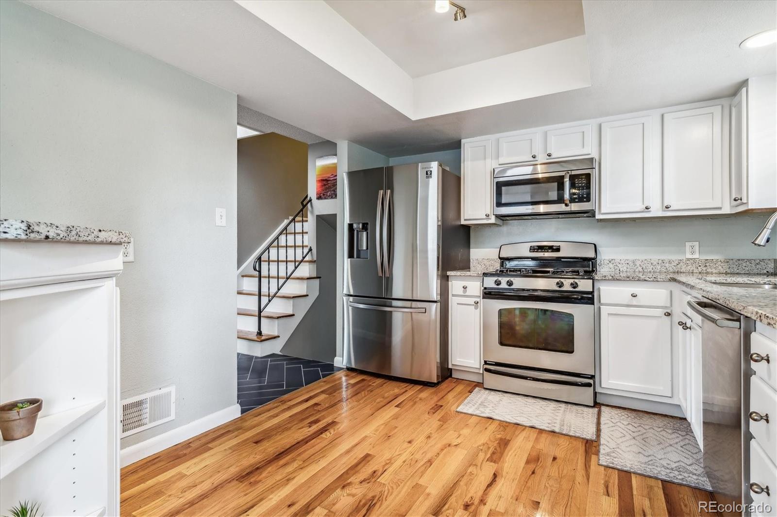 4844 Scranton Court Denver, CO 80239 - Photo 5 of 25 a kitchen with stainless steel appliances a stove a sink and a refrigerator