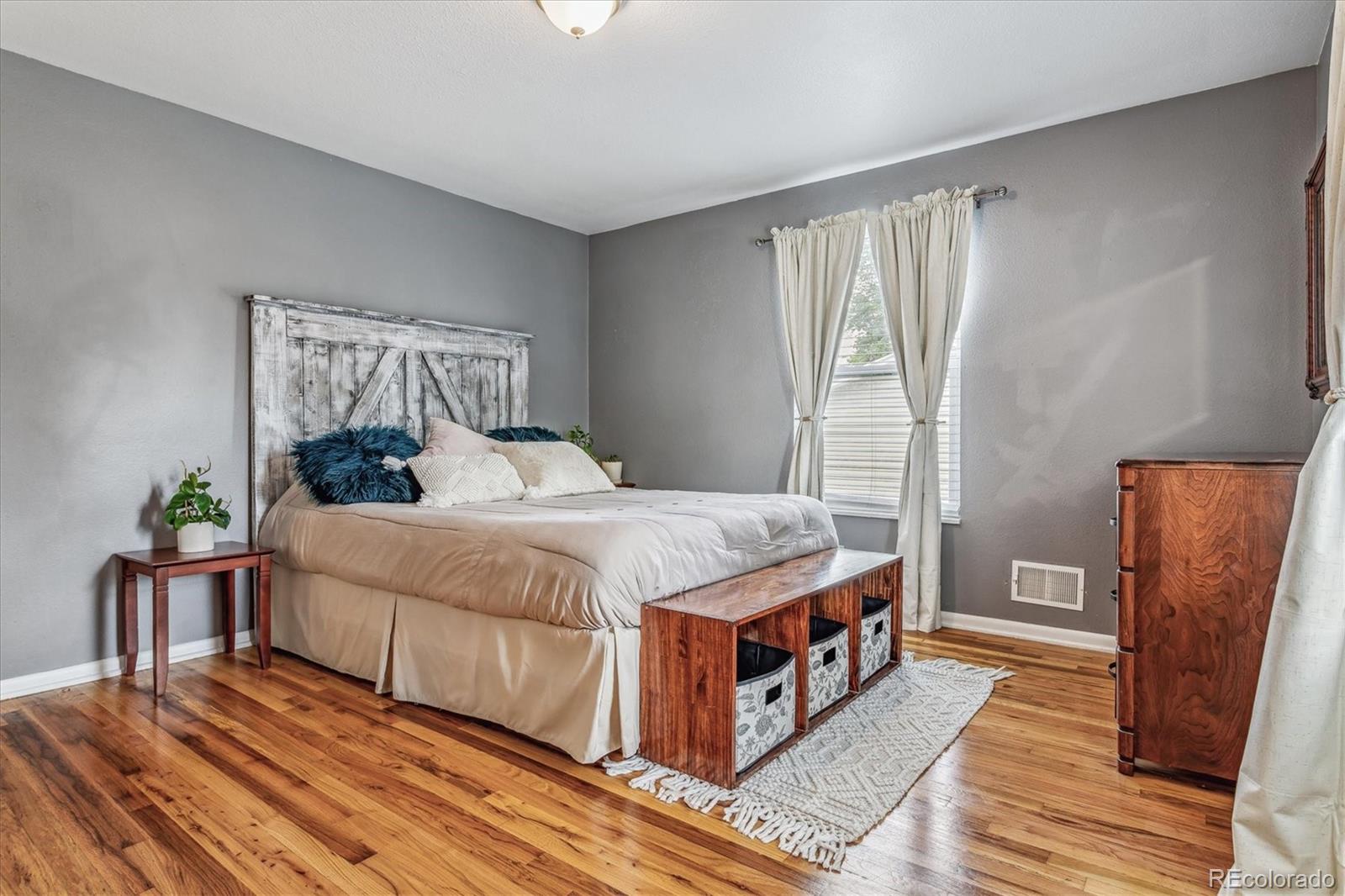 4844 Scranton Court Denver, CO 80239 - Photo 6 of 25 a bedroom with a bed and wooden floor
