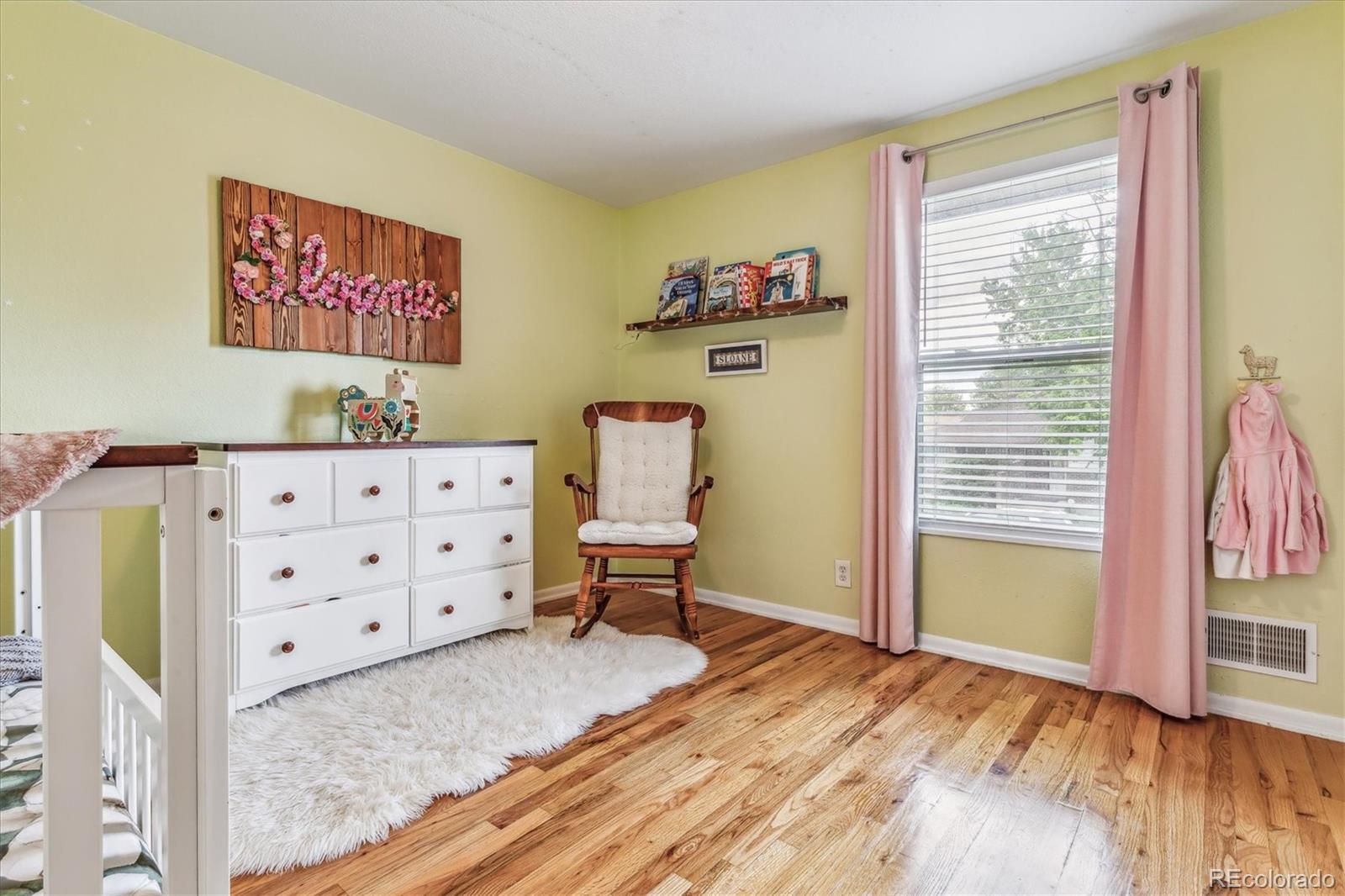4844 Scranton Court Denver, CO 80239 - Photo 10 of 25 a view of a bedroom with baby bed and lounge chair