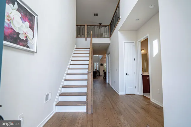 a view of a hallway with wooden floor and stairs