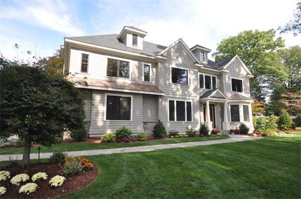 a front view of a house with a garden and trees