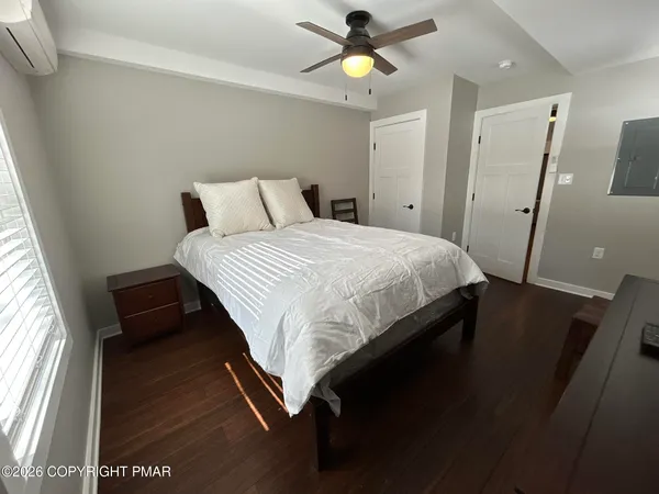 a bedroom with a bed and a lamp on dresser