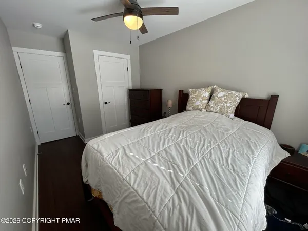 a bedroom with a bed and a lamp on dresser
