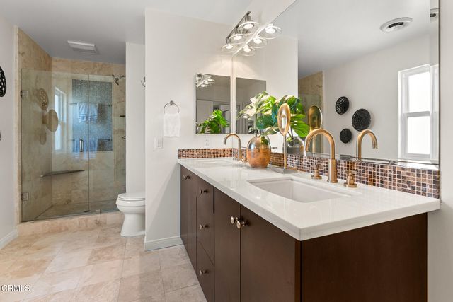 a bathroom with a double vanity sink mirror and toilet