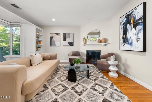 a living room with furniture a fireplace and a large window