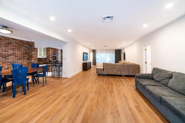 a living room with furniture and kitchen view