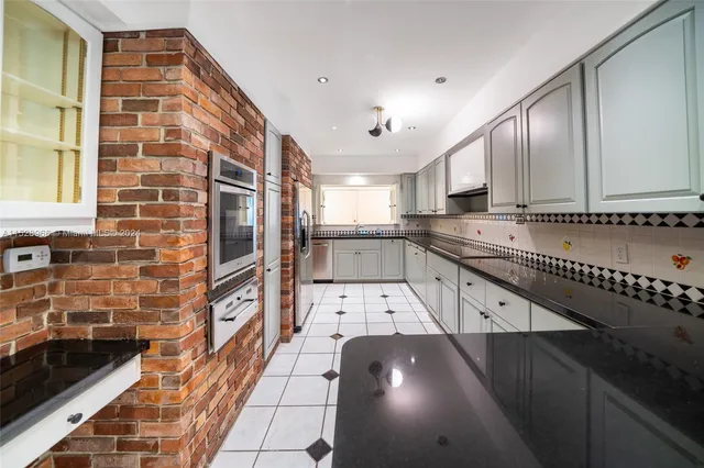 a kitchen with stainless steel appliances granite countertop a sink and cabinets