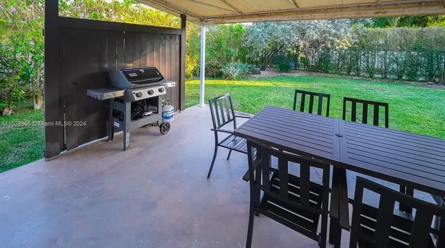 a view of a patio with a table chairs and a yard