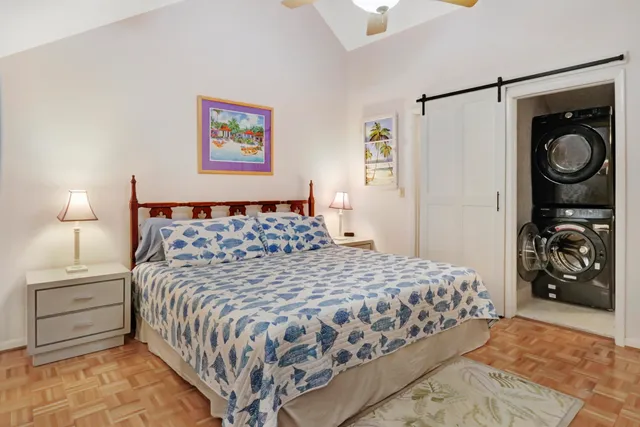 a bedroom with a bed and a lamp on the dresser