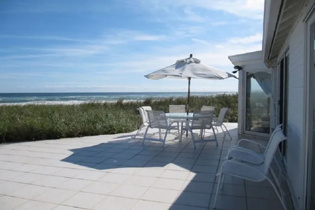 a view of a patio with a table and chairs under an umbrella