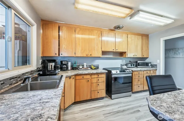 a kitchen with stainless steel appliances granite countertop a stove a sink and a microwave