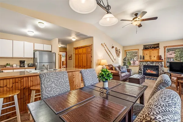 a living room with furniture kitchen view and a chandelier