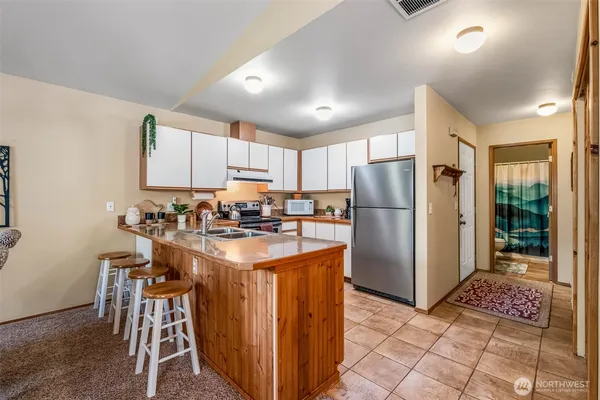 a kitchen with stainless steel appliances granite countertop a refrigerator and a stove top oven