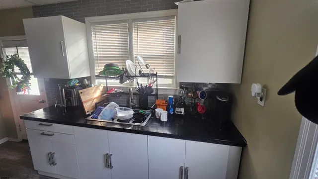 a kitchen with sink a window and cabinets