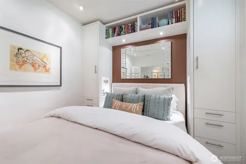 a bedroom with a bed and a painting on the wall