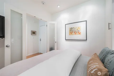 a bedroom with a bed and a painting on the wall