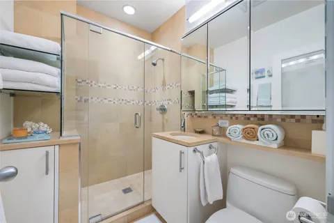 a bathroom with a sink a toilet and shower