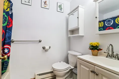 a bathroom with a toilet sink and mirror