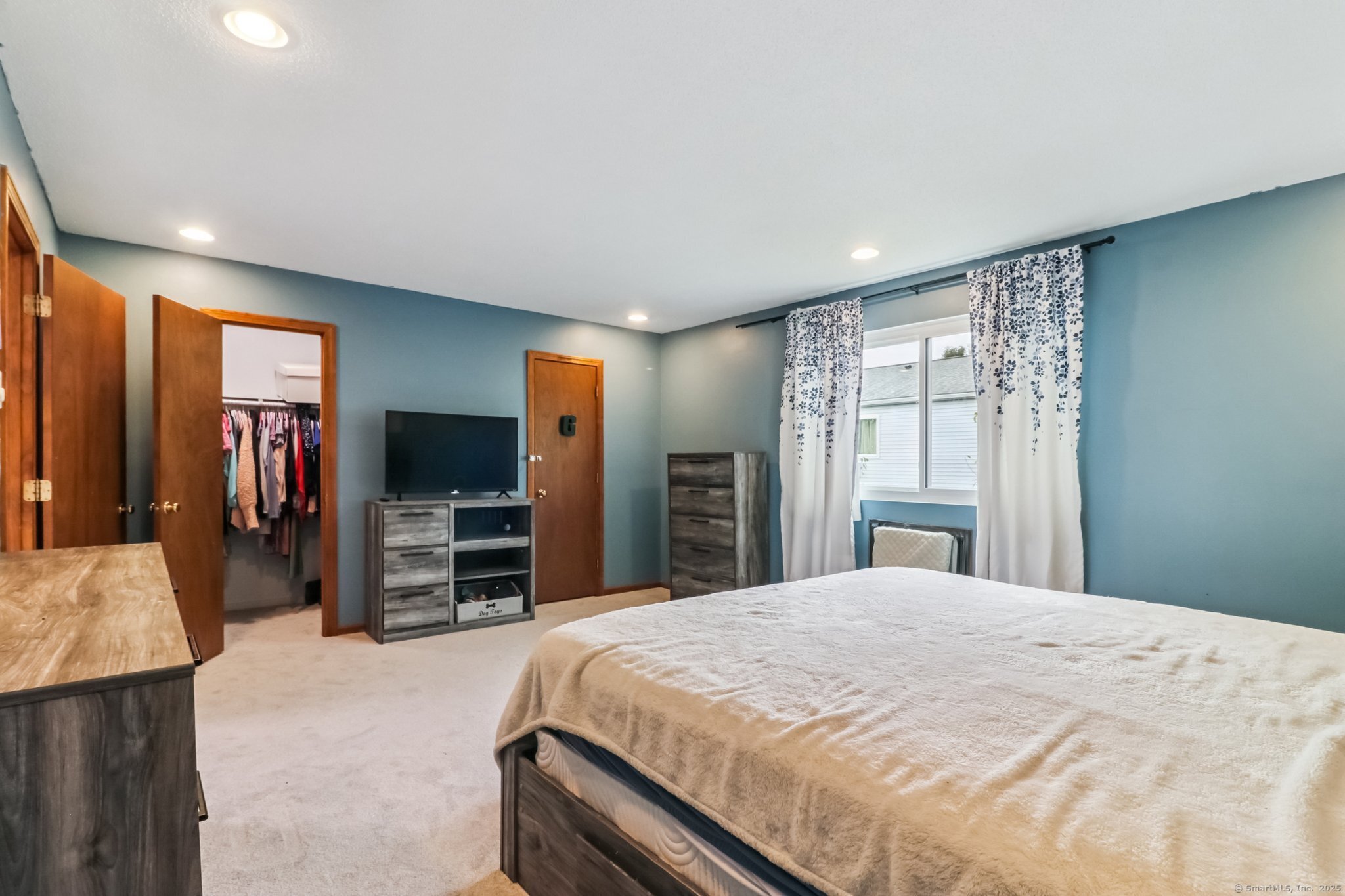 565 Clark Avenue, Unit 18 Bristol, CT 06010 - Photo 19 of 25 a bedroom with a large bed and a flat tv screen on dresser