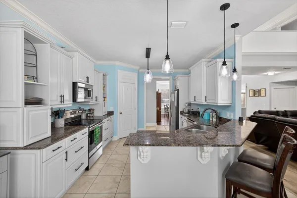 a kitchen with granite countertop white cabinets white appliances and sink