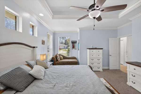 a bedroom with a bed a book shelf and a window