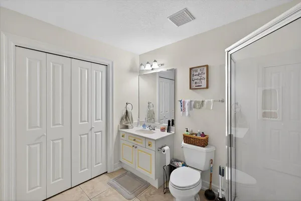 a bedroom with furniture and a air conditioner vent