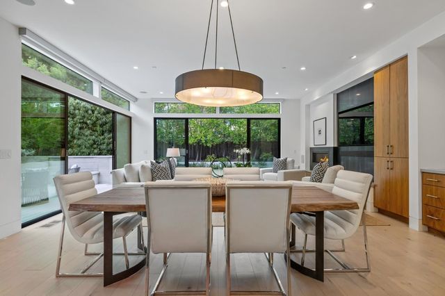a kitchen with kitchen island a stove a table and chairs in it