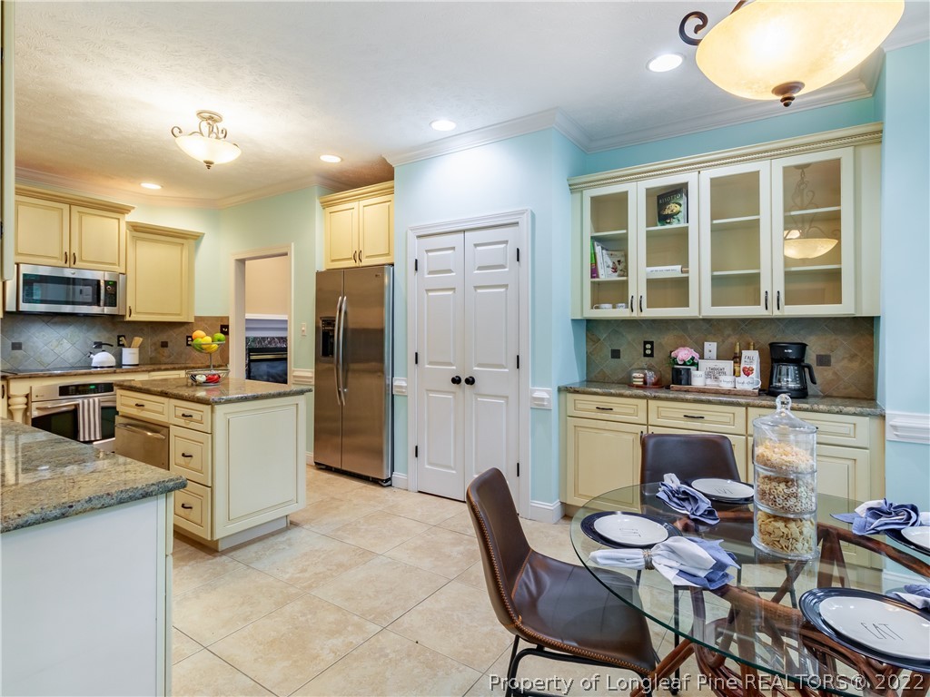 6915 Surrey Road Fayetteville, NC 28306 - Photo 16 of 37 a kitchen with a refrigerator and cabinets