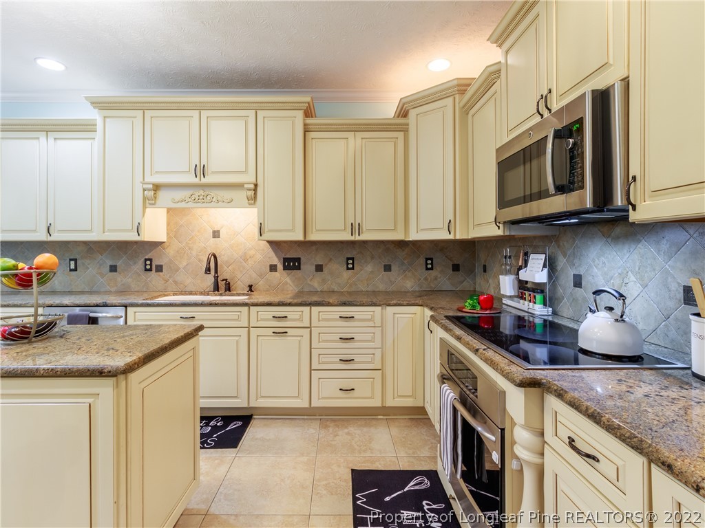 6915 Surrey Road Fayetteville, NC 28306 - Photo 17 of 37 a kitchen with stainless steel appliances granite countertop a sink stove and microwave