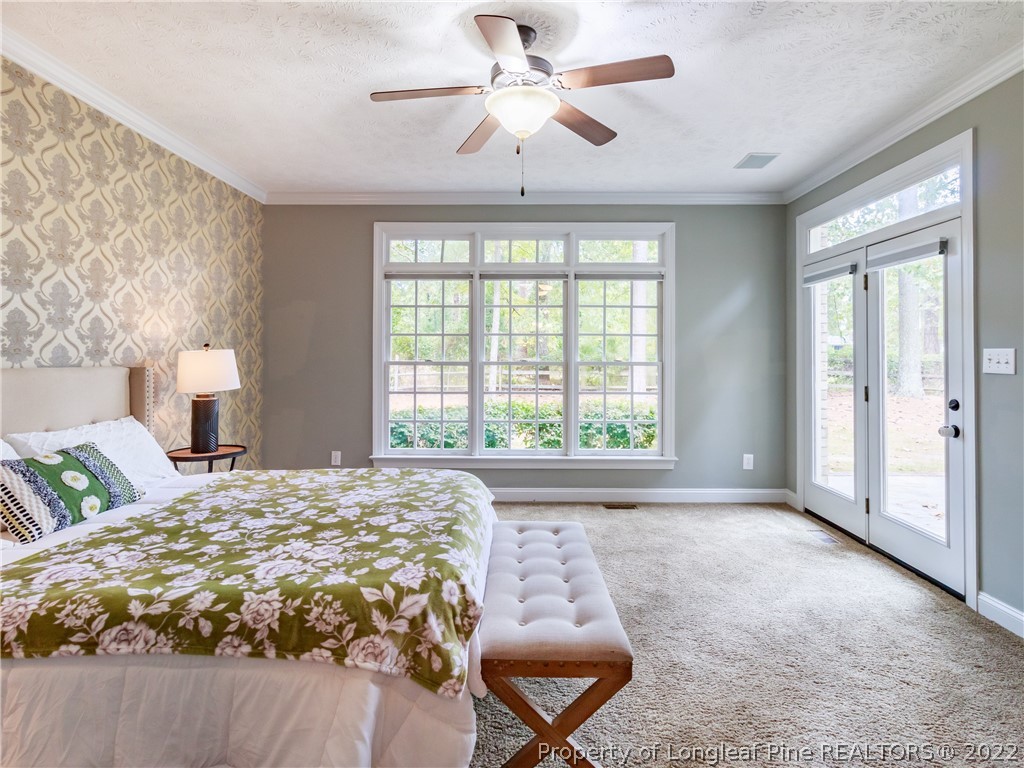 6915 Surrey Road Fayetteville, NC 28306 - Photo 22 of 37 a bedroom with a large bed and a chandelier fan