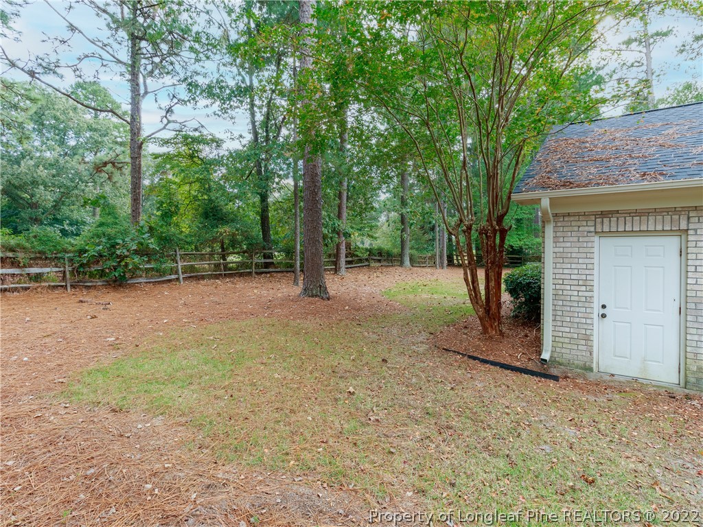 6915 Surrey Road Fayetteville, NC 28306 - Photo 34 of 37 a view of a backyard with large trees and a small barn